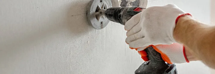 Bohrer mit Lochsäge in Wand